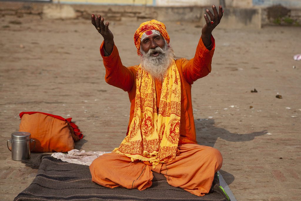 Man in India with hand raised giving a greeting.