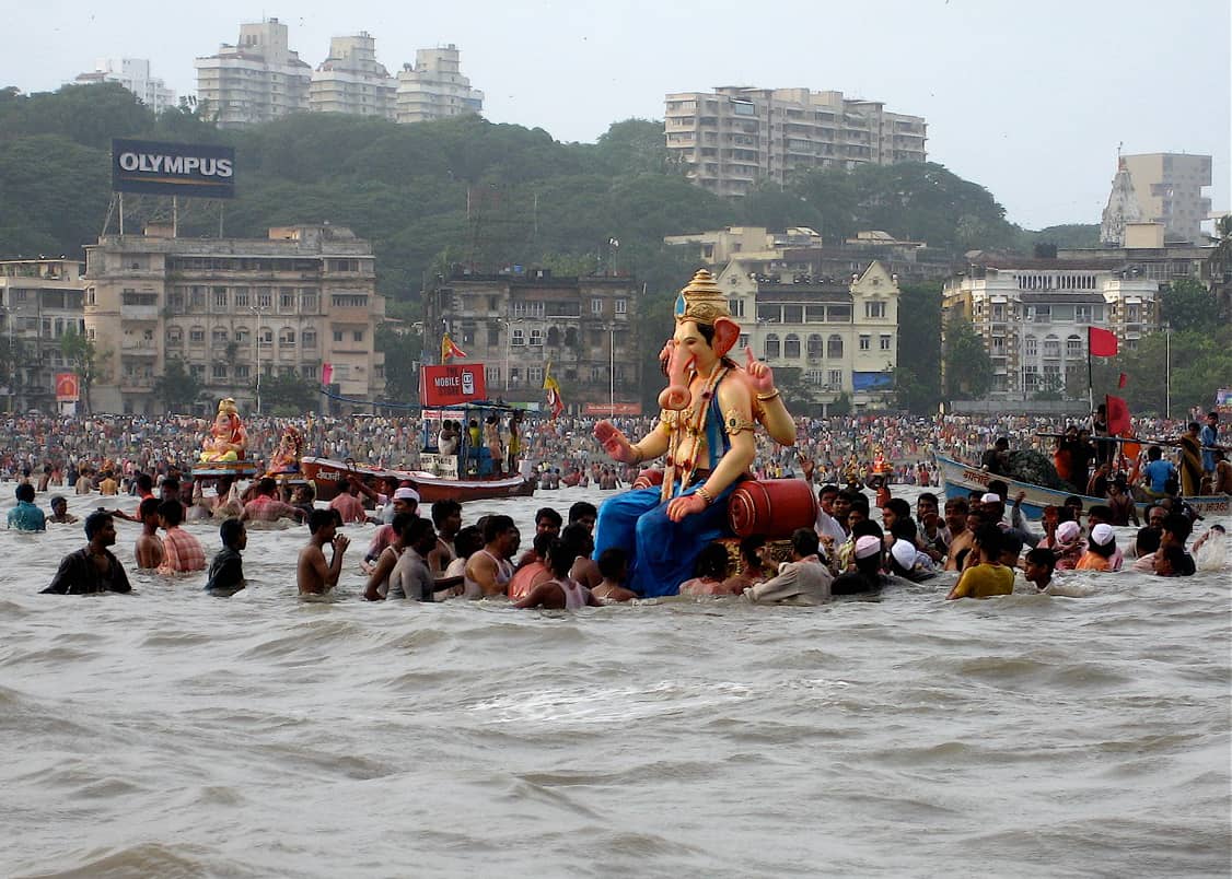 Devotees wading into the water with a giant Ganesh statue for the Ganesh Chaturthi visarjan ceremony in India.